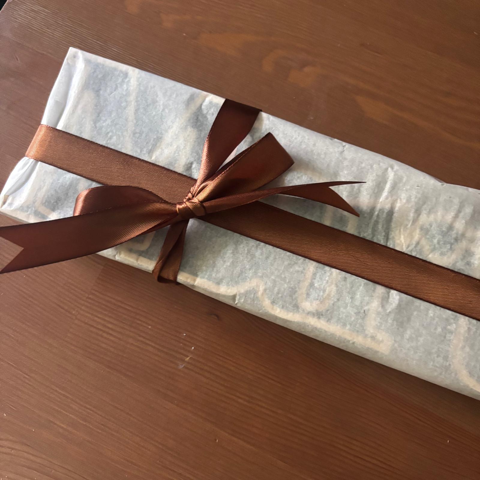 Empaquetado de regalo artesanal con papel de seda, lazo de tela y caja de regalo